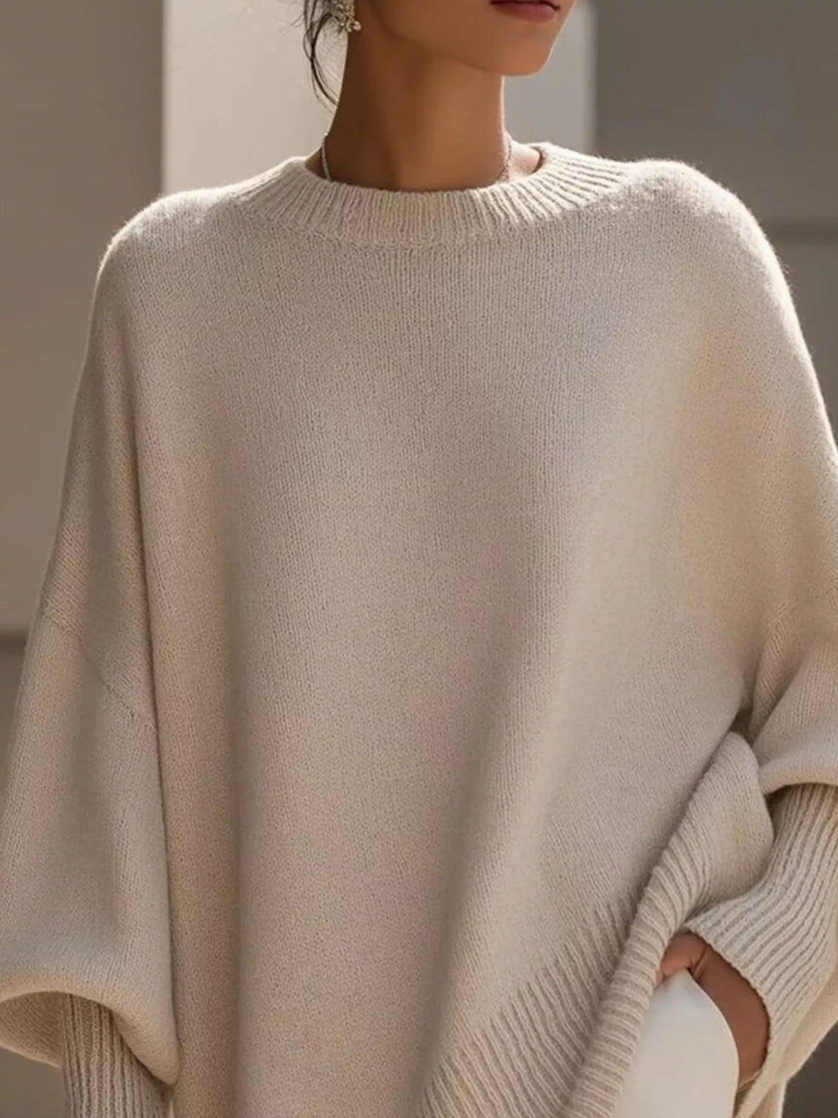 Damski sweter oversize z szerokimi rękawami i asymetrycznym dołem