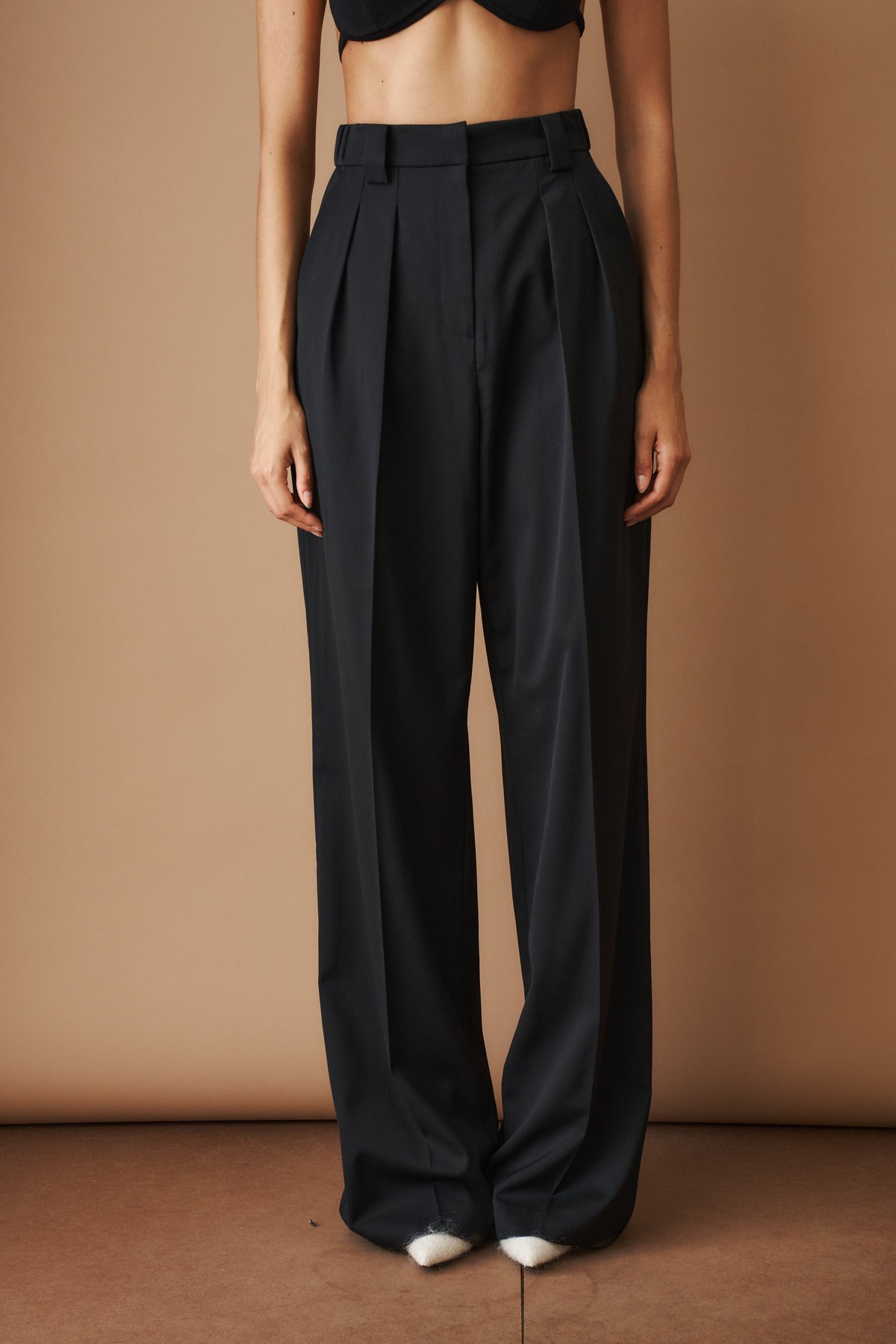 Czarne damskie spodnie z wysokim stanem, zakładkami i szerokimi długimi nogawkami